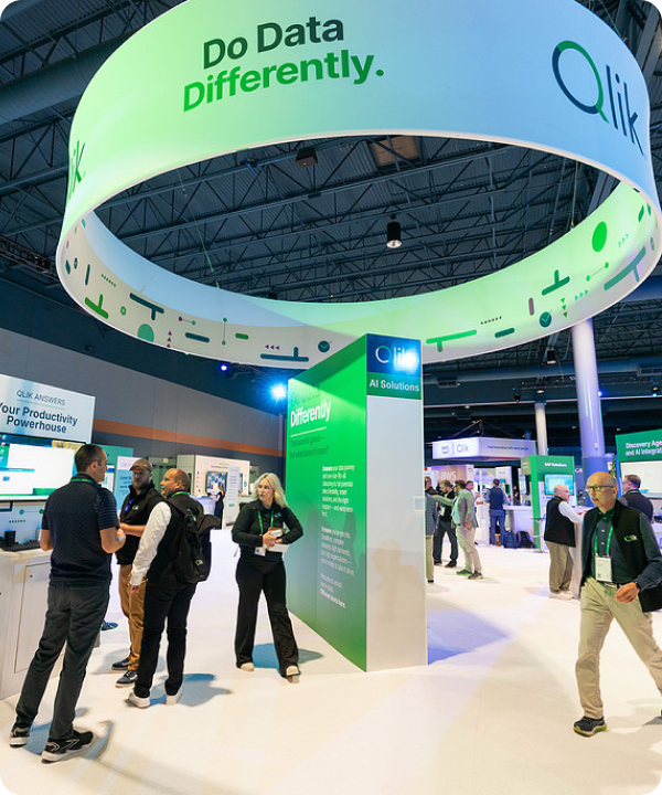 Attendees walk through a busy Qlik exhibition hall under a large, circular "Do Data Differently" hanging banner.