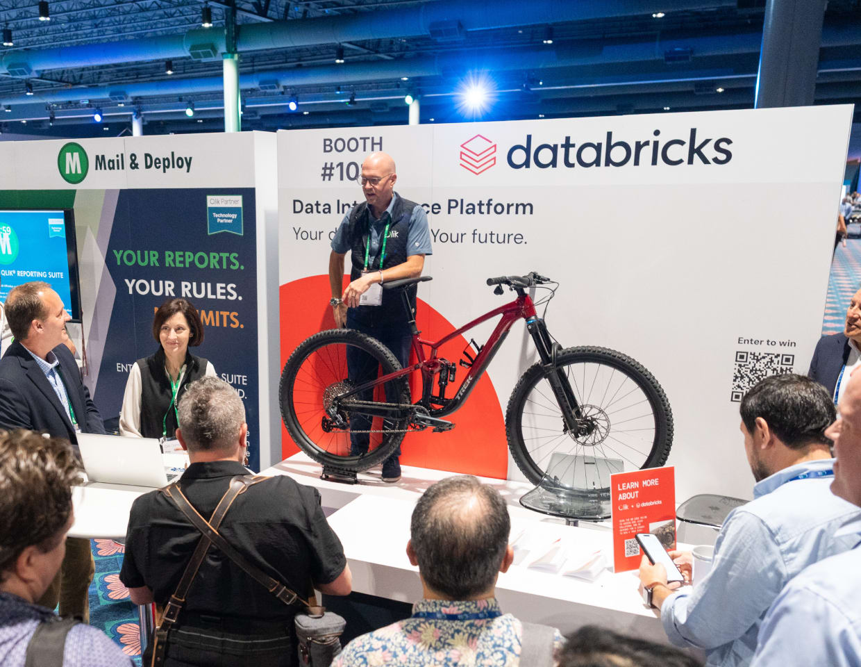 A Databricks exhibition booth featuring a mountain bike giveaway, with a presenter engaging attendees.
