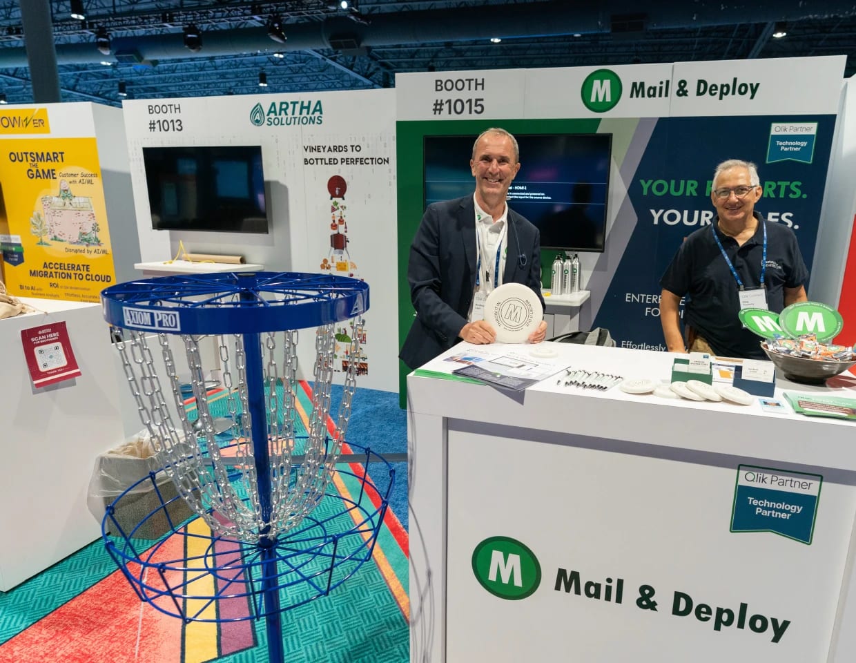 Attendees participate in an interactive cycling activity at a Qlik event, engaging with data-driven fitness displays and networking around various demo stations in a lively exhibition environment.