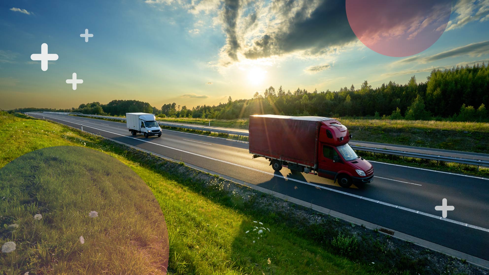 Two trucks drive on a highway under a partly cloudy sky with the sun low on the horizon. The highway is surrounded by green grass and trees. Plus and circle-shaped graphics are overlaid on the image.