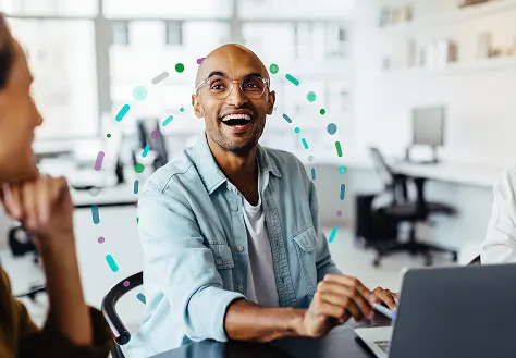 A man joyfully engaging with others in a work environment