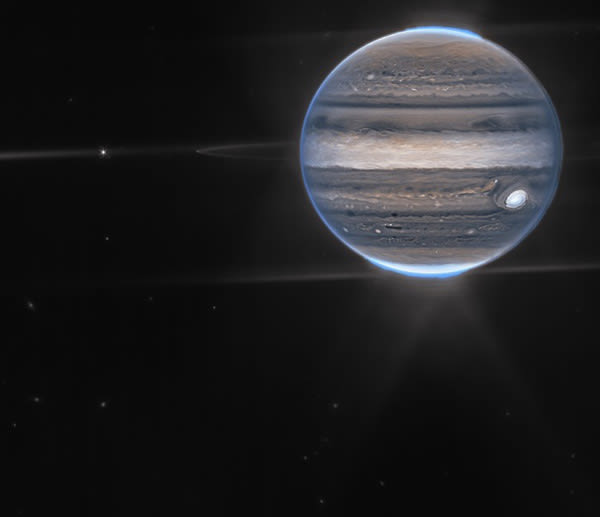 A detailed image of Jupiter, showing its distinct bands of clouds and the Great Red Spot, with its faint rings visible against a black background of space.
