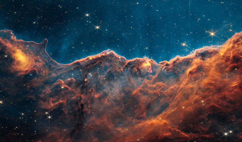 Image of the Carina Nebula captured by the James Webb Space Telescope, showing detailed interstellar clouds and star formations against a backdrop of deep space.