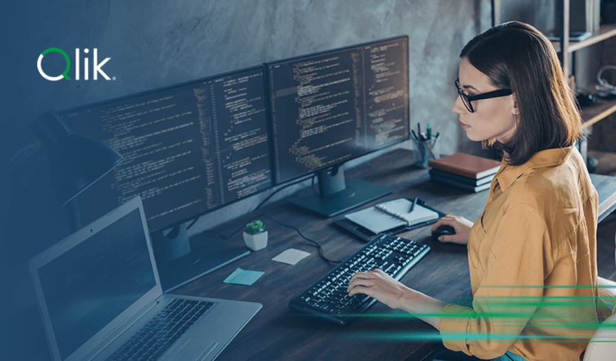 Promotional banner featuring a woman in a mustard yellow shirt using dual monitors displaying code. The graphic has a dark teal overlay and text: "Unlocking mainframe data for modern cloud uses," powered by Qlik and AWS.